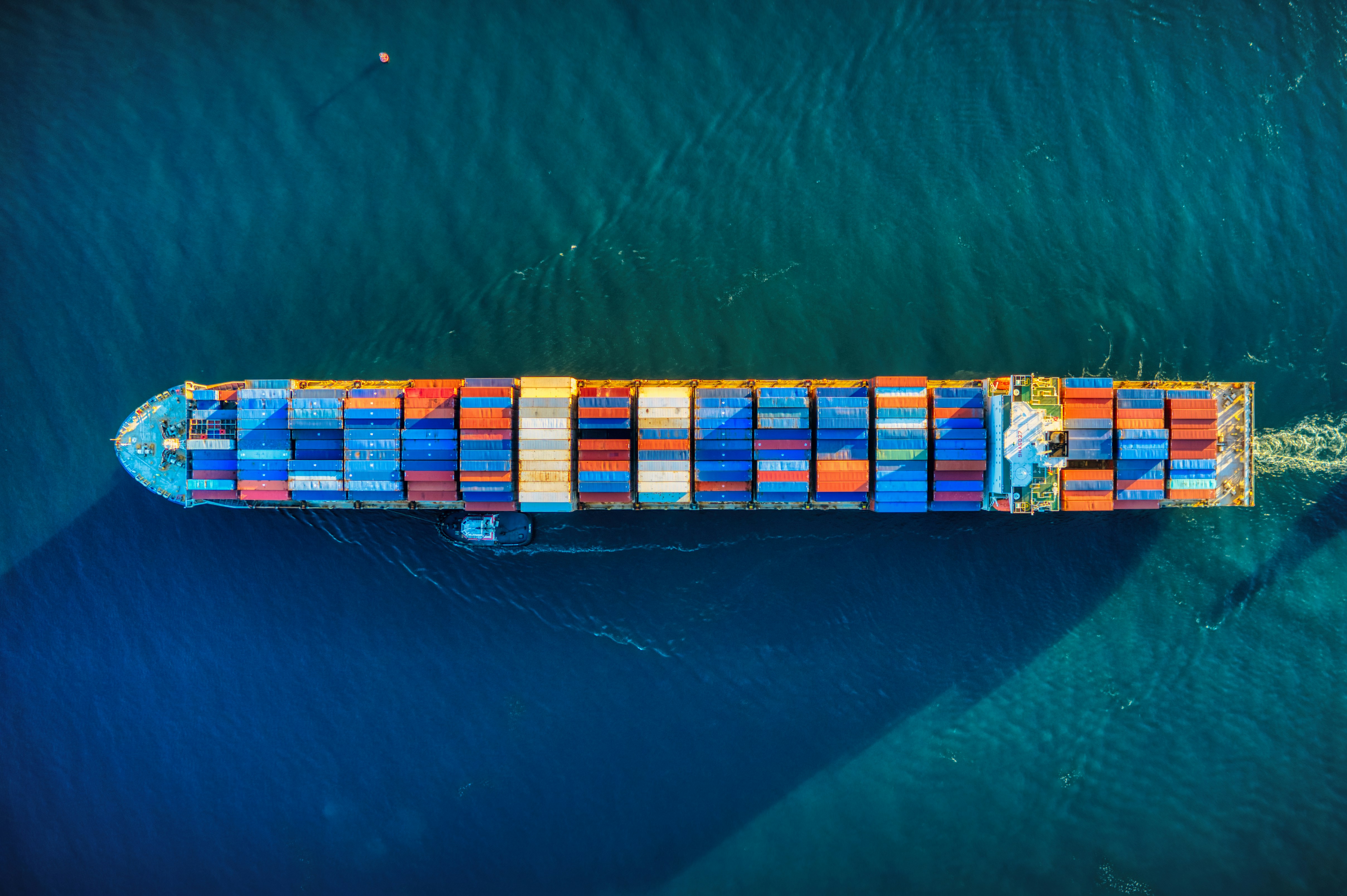 Aerial view of a container vessel underway, representing FMGL's ocean freight service.